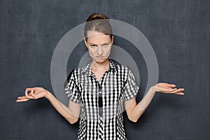 Portrait of angry indignant young woman raising hands