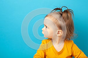 Portrait of angry little girl on blue background with copy space