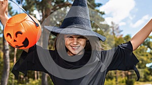 Portrait of an angry little girl in a witch costume, outside. halloween