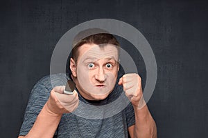 Portrait of angry man holding knife and shaking fist
