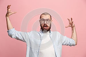 Portrait of an angry man looking at camera isolated on a pink background