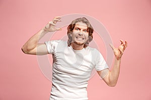 Portrait of an angry man looking at camera on a pink background