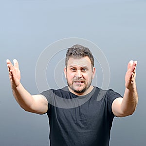 Portrait of a angry man screaming against gray background