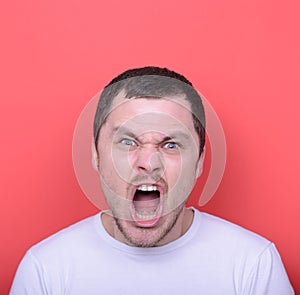 Portrait of angry man screaming against red background