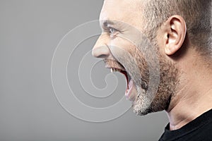 Portrait of angry man sreaming isolated on gray background