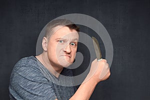 Portrait of angry man swinging knife and being ready to attack