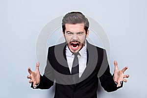 Portrait of angry overworked businessman sreaming in rage becaus