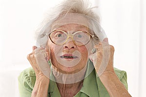 Portrait of an angry senior lady with eyes glasses