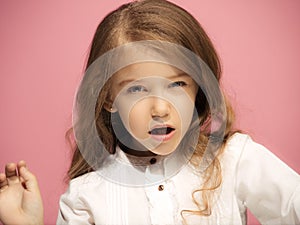 Portrait of angry teen girl on a pink studio background