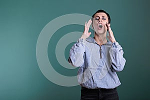 Portrait of angry unhappy woman having agressive emotion screeming while posing in studio photo