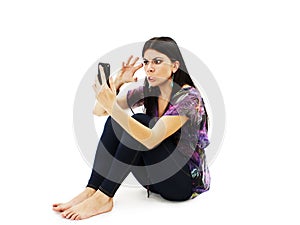 Portrait of an angry woman with clenched fist looking at her cellphone