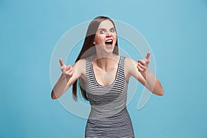 Portrait of an angry woman looking at camera isolated on a blue background