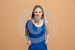 Portrait of an angry woman looking at camera on a pastel background