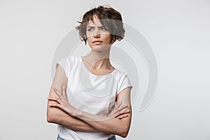 Portrait of angry woman with short brown hair in basic t-shirt frowning and looking at camera