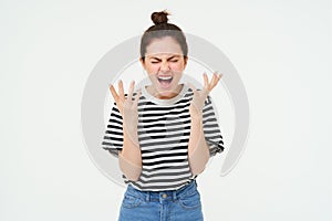 Portrait of angry woman shouting and shaking hands, losing her temper, arguing, standing over white background