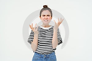 Portrait of angry woman shouting and shaking hands, losing her temper, arguing, standing over white background