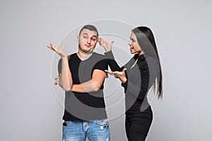 Portrait of an angry young couple shouting and quarrel having an argument isolated over gray background