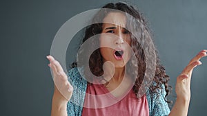 Portrait of angry young lady yelling gesturing fighting looking at camera