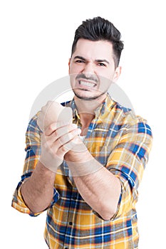 Portrait of angry young man with pain in his wrist