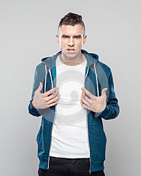 Portrait of angry young man pointing at his white t-shirt