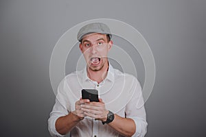 portrait of angry young man shouting using mobile