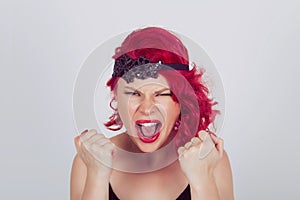 Portrait angry young woman screaming fists clenched