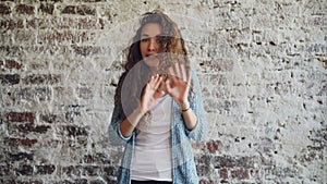 Portrait of angry young woman talking and gesturing expressing negative emotions standing indoors with loft style