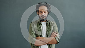 Portrait of annoyed and bored mixed race man yawning and looking at camera with unhappy face