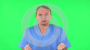 Portrait of annoyed medical man gesturing in stress expressing irritation and anger. Green screen