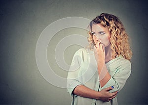 Portrait anxious woman biting her fingernails craving for something