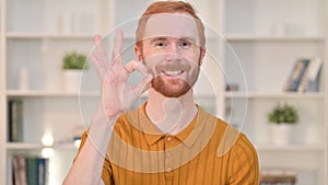 Portrait of Appreciative Redhead Man doing OK Sign