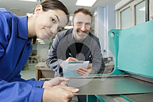 Portrait apprentice working with engineer on cnc machine