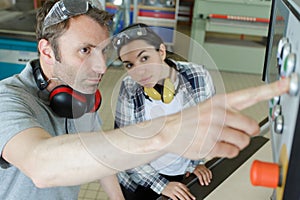 portrait apprentice working with engineer on cnc machine