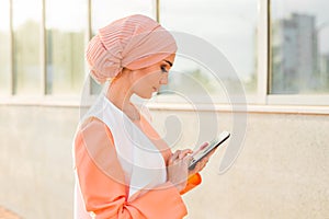 Portrait of Arab businesswoman holding a tablet. The woman is dressed in an abaya