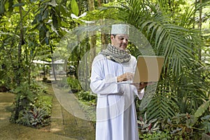Portrait of Arab muslim business man dress in white thobe with p photo