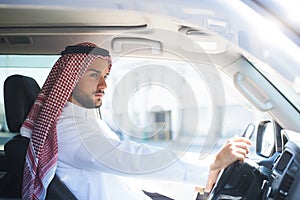 Portrait of an arabian man driving a car