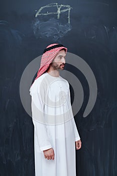 Portrait of arabian man in front of black chalkboard