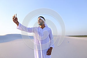 Portrait of Arabian sheikh man with gadget that communicates in