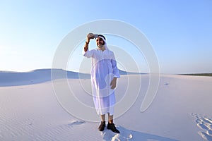 Portrait of Arabian sheikh man with gadget that communicates in