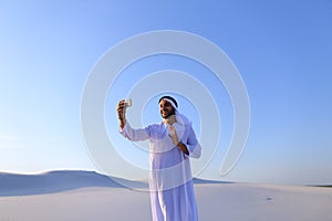 Portrait of Arabian sheikh man with gadget that communicates in