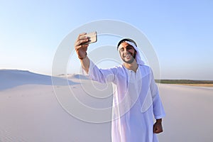 Portrait of Arabian sheikh man with gadget that communicates in