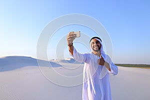 Portrait of Arabian sheikh man with gadget that communicates in