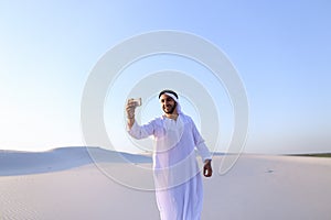 Portrait of Arabian sheikh man with gadget that communicates in