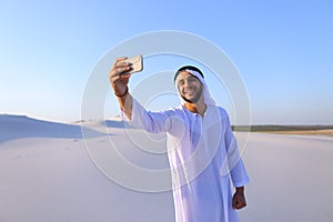 Portrait of Arabian sheikh man with gadget that communicates in