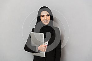 Portrait of arabic smiling woman 20s in black traditional hijab