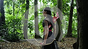 Portrait of archery woman walking fearless and bravely in the jungle
