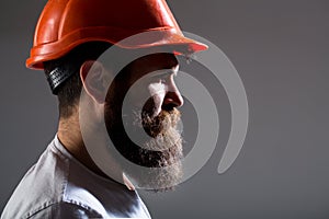 Portrait architect builder, civil engineer working. Builder in hard hat, foreman or repairman in the helmet. Bearded man