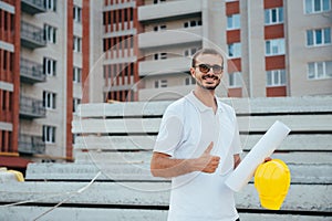 Portrait of an architect builder studying layout plan of the rooms, serious civil engineer working with documents on