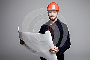 Portrait of an architect builder studying layout plan of the rooms, serious civil engineer working with documents on construction