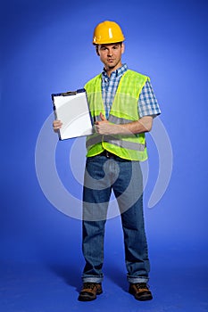 Portrait of architect holding clipboard and showing thumbs up sign